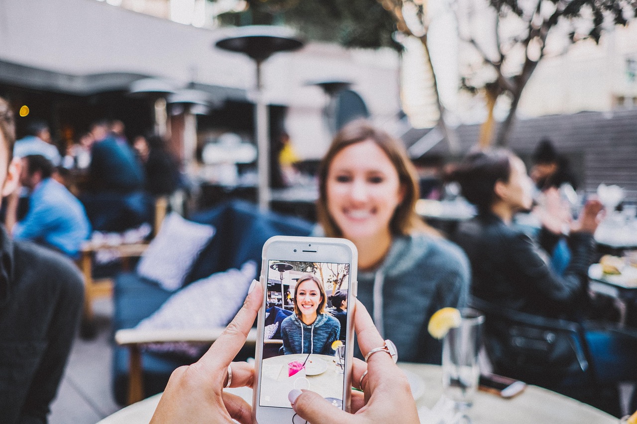 A person capturing a photo on their phone in a restaurant, the kind of content that makes social media work for a local business