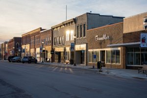 Small town main street lined with local storefronts at sunset, representing a service area across nearby towns