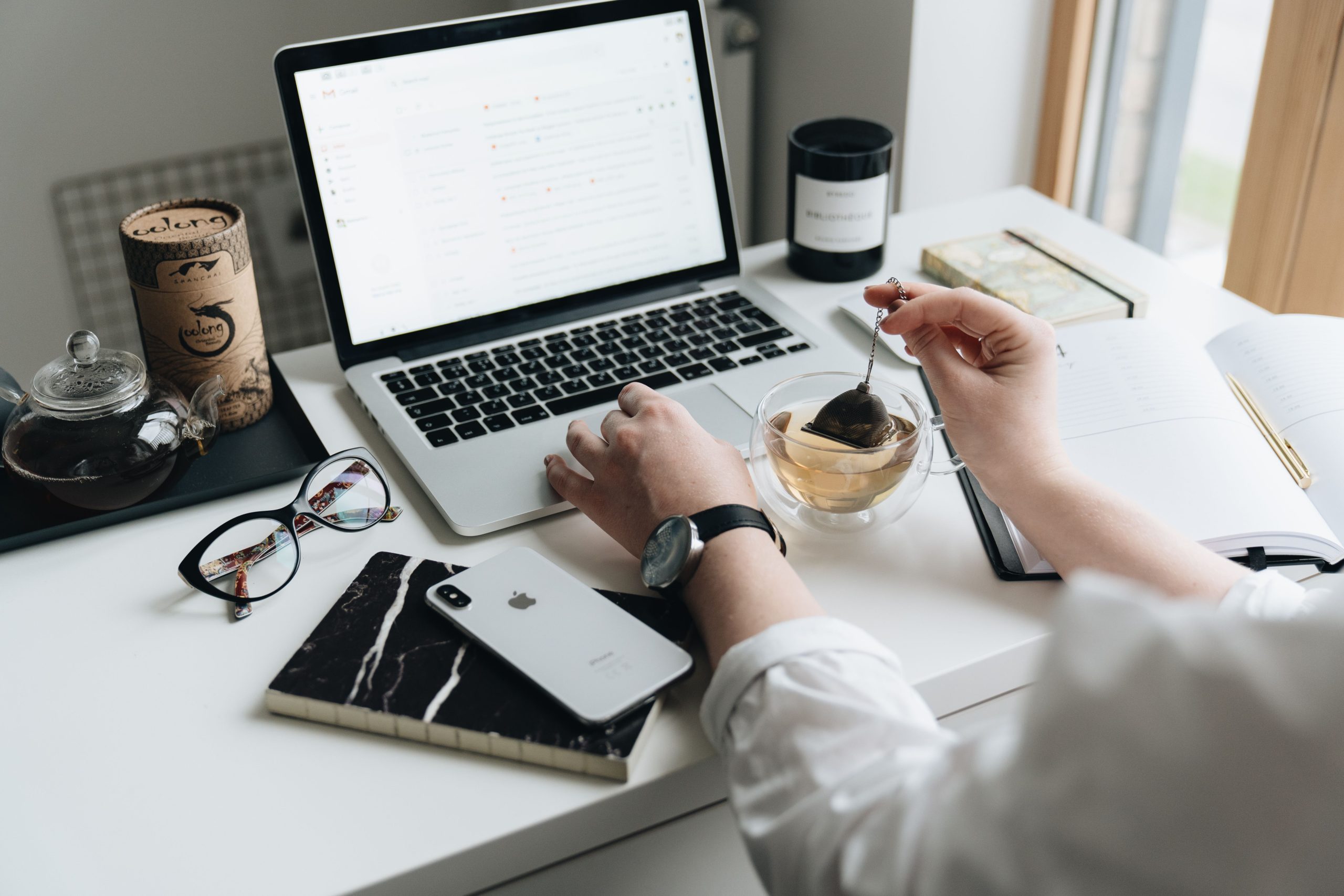 A laptop and tea on a home desk, where a past customer reads the email that brings them back