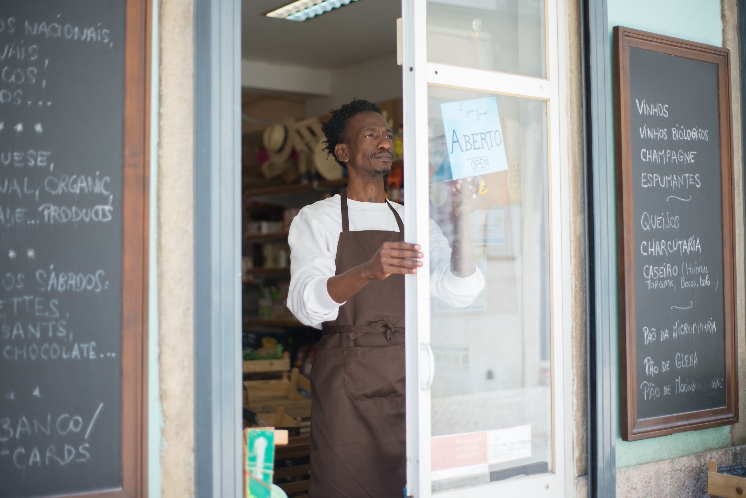 Local shop owner opening the door of a small storefront, ready for nearby customers
